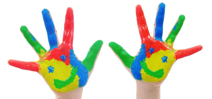 Manos pequeñas manchadas con pintura de dedos de colores rojo, amarillo, azul y verde.